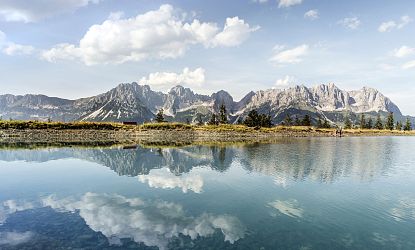 Alpenpanorama mit Bergsee im Vordergrund.