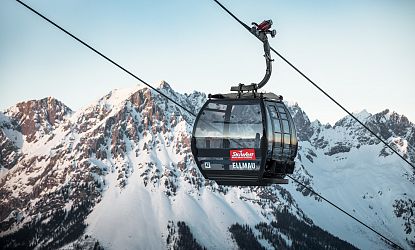 Schwarze Gondel Hartkaiserbahn in Ellmau mit dem verschneiten Wilden Kaiser im Hintergrund