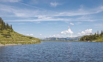 Ein klarer See inmitten von Bergen und unberührter Natur.
