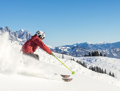 Skifahrer flitzt die Piste hinab in der SkiWelt Wilder Kaiser-Brixental.