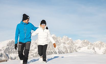Zwei Winterwanderer die von der Brandstadl Bergstation zum Brandstadlkreuz in Scheffau wandern.